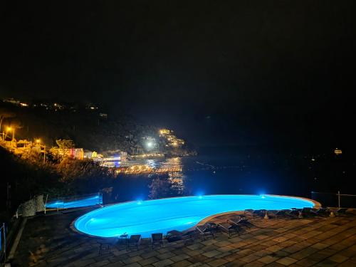 una grande piscina notturna con vista di Marina del Cantone Chalet a Nerano