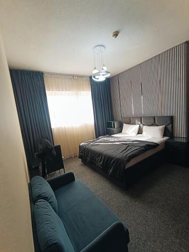 a bedroom with a bed and a couch and a window at ApartHotel Rooms in Ajman