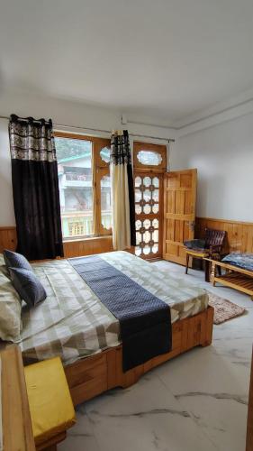 a large bed in a room with a large window at Rana Ridges in Banjār