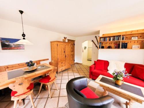 a living room with a red couch and a table at Apartment Curtins18 by Interhome in Pontresina
