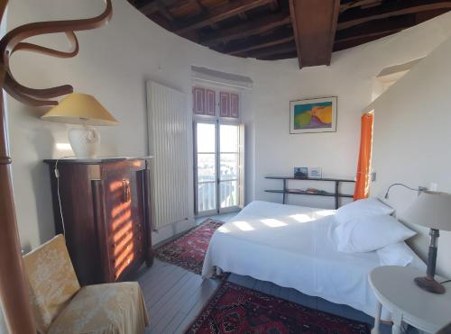 een slaapkamer met een wit bed en een stoel bij Tour-Moulin in Épire