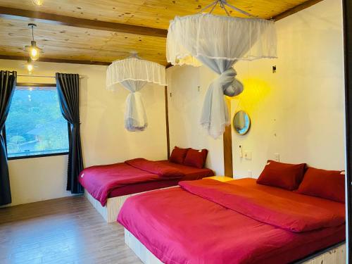 two beds in a room with wooden ceilings at Nhà Dâu Homestay in Muong Cha