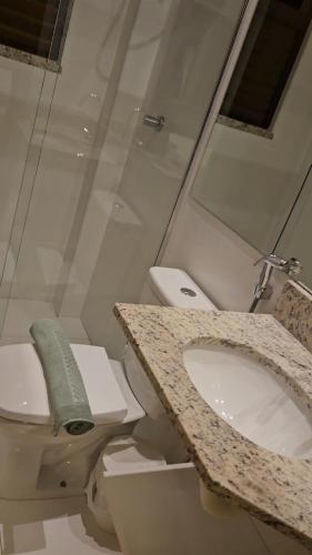 a bathroom with a toilet and a sink at Itacimirim Bioflora 69 in Itacimirim