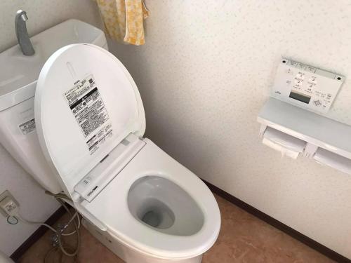 a bathroom with a toilet with the lid up at PhaseSpace in Sekimachi