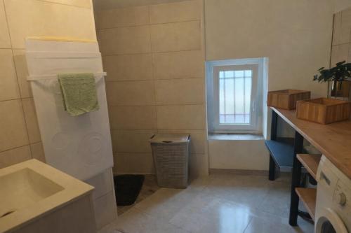 eine kleine Küche mit Spüle und Fenster in der Unterkunft Appartement Terrasse à Mennetou sur Cher "La Cité Médiéval in Mennetou-sur-Cher