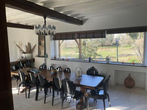 ein Esszimmer mit einem großen Holztisch und Stühlen in der Unterkunft La Bastide in Armous-et-Cau