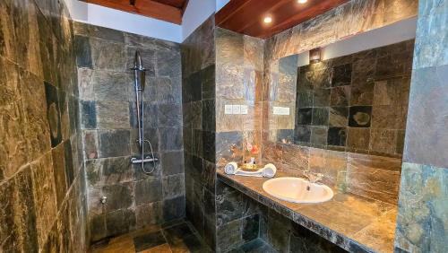 een badkamer met een wastafel en een douche bij Villa Kusum in Hikkaduwa