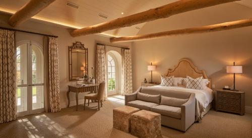 een slaapkamer met een bed, een stoel en een bureau bij Leeu Estates in Franschhoek