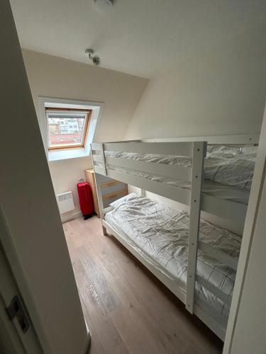a bedroom with two bunk beds and a window at Residence Rodin in Nieuwpoort