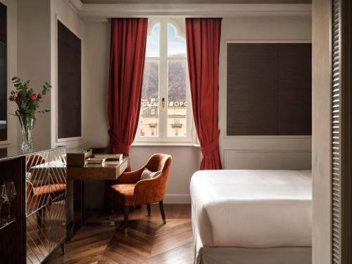 een slaapkamer met een bed, een bureau en een raam bij Palazzo Venezia in Como