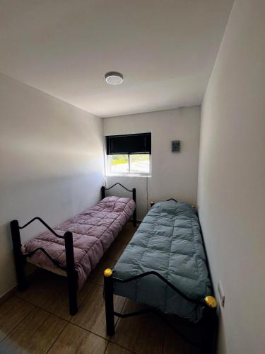 a bedroom with two beds and a window at La unión in Ciudad Lujan de Cuyo