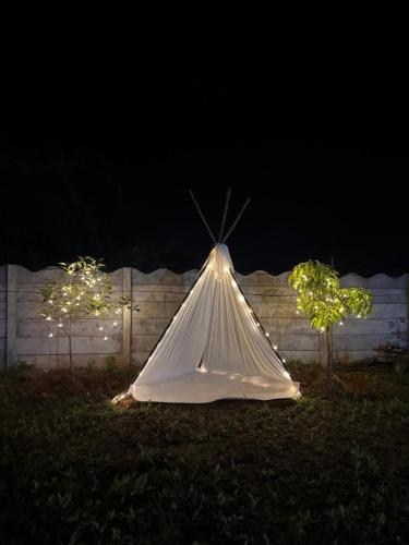 ein weißes Tipi-Zelt im Gras bei Nacht in der Unterkunft Soulstay Resort in Chinchavli