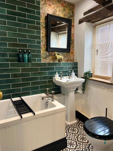 a bathroom with a sink and a tub and a toilet at Foundry Cottage, Duke St Norwich, City Centre in Norwich