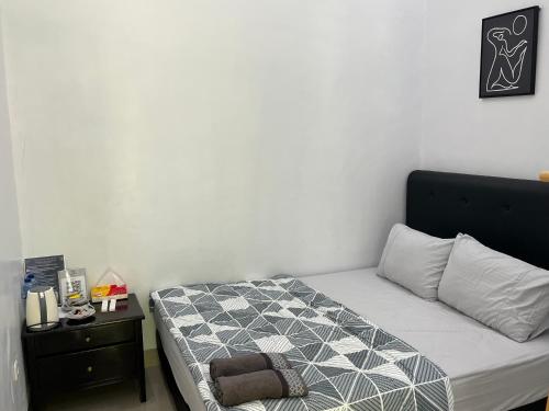 una camera da letto con un letto con un piumone bianco e nero di Damar Tree Resort a Krui