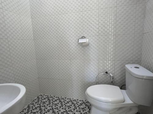 un bagno bianco con un water e un lavandino di Damar Tree Resort a Krui