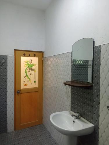 a bathroom with a sink and a mirror and a door at White Horizon 2 in Ahangama
