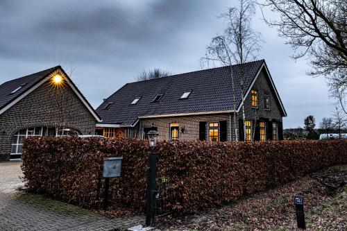 a house with a hedge in front of a house at Aan `t Krakeel in Noordscheschut