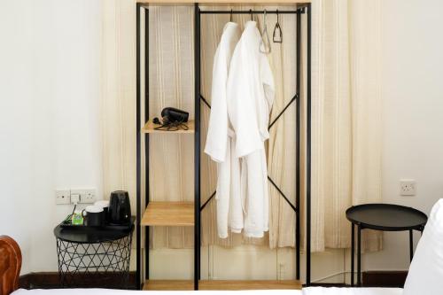 een kledingkast in een slaapkamer met een witte badjas bij Semiramis Boutique Hotel & Spa in Kato Platres