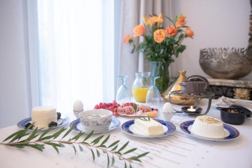 a table with plates of food on a table with flowers at L'Hôtel Particulier La Marsa in La Marsa