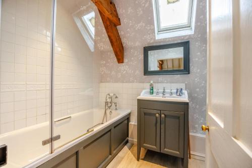 een badkamer met een bad en een wastafel en een ligbad bij 1 Bed in Chedworth oc-o30916 in Chedworth