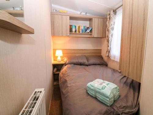 a small bedroom with a bed in a small room at Caravan number 77 in Eyemouth
