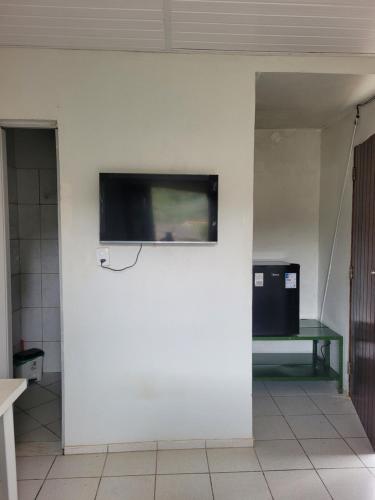 una TV a schermo piatto su una parete bianca di Sítio Guanabara a Guaramiranga
