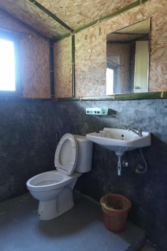 a bathroom with a toilet and a sink at จรรยา โฮมสเตย์ in Chom Thong