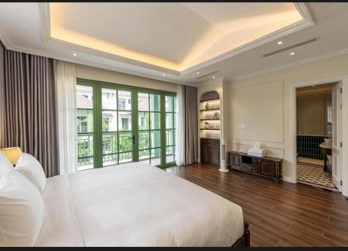 a bedroom with a large bed and a large window at Green Villas Tropical Phú Quốc in Phu Quoc