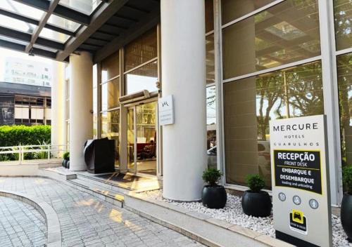 eine Ladenfront mit einem Schild vor einem Gebäude in der Unterkunft GRU Airport Easy Stay in Guarulhos