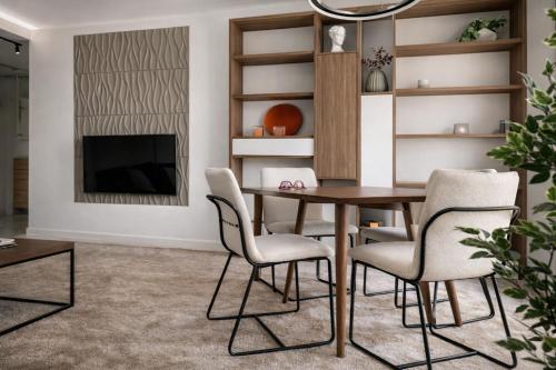 a dining room with a table and chairs and a tv at Séjour réussi à deux pas de Genève appartement 57m2 in Ferney-Voltaire