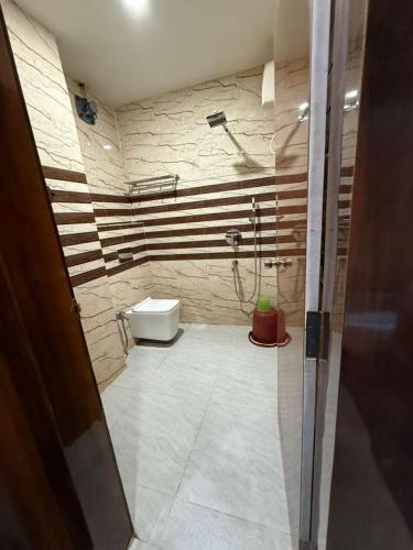 a bathroom with a shower and a toilet at Hotel Tazzodisha Next in Bhubaneshwar