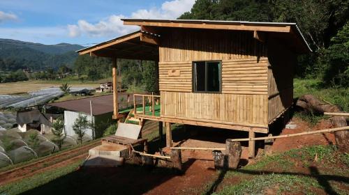 een klein houten huisje op een stapel boomstammen bij จรรยา โฮมเสตย์ in Chom Thong