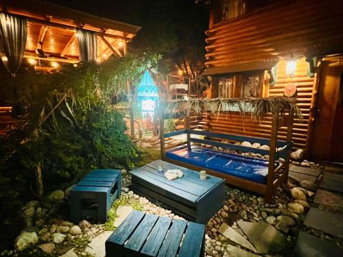 een houten bed voor een hut 's nachts bij Infinito Chill0ut in San Marcos Sierras