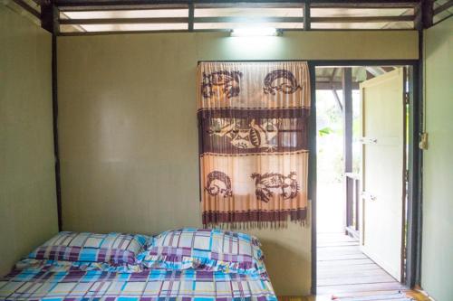 um quarto com uma cama com uma cortina na parede em Weekender Bungalow em Lamai
