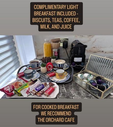 ein Tisch mit einem Tablett mit Frühstücksspeisen darauf in der Unterkunft Modern Studio Luxe Heathrow London in New Bedfont