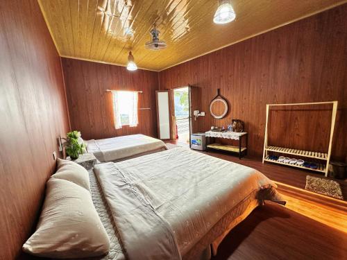 een slaapkamer met een groot bed in een houten muur bij Nà Bó Homestay in Mộc Châu