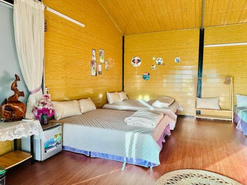 een slaapkamer met een bed en een houten wand bij Nà Bó Homestay in Mộc Châu