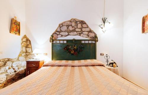 een slaapkamer met een groot bed met een groot hoofdeinde bij Agriturismo Lillastro Grosseto in Braccagni