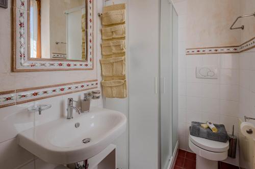 une salle de bains avec lavabo, toilettes et miroir dans l'établissement Agriturismo Villa Beatrice, à Mondavio