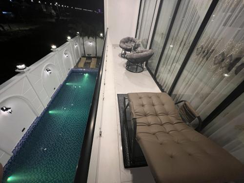 einen Balkon mit einem Pool, 2 Stühlen und einem Tisch in der Unterkunft H99 Homestay 