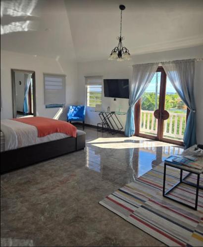 a large bedroom with a bed and a balcony at Thrush Nest View Studio Apartment in The Valley