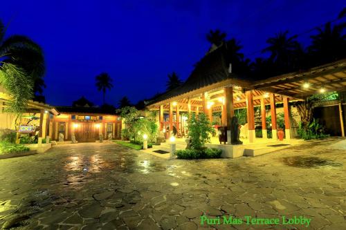 a night view of a building with a courtyard at Puri Mas Boutique Resort & Spa in Senggigi 