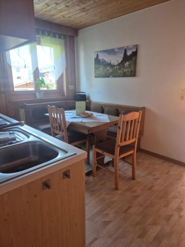 a kitchen and dining room with a table and chairs at Winklgut Bacher in Uttendorf
