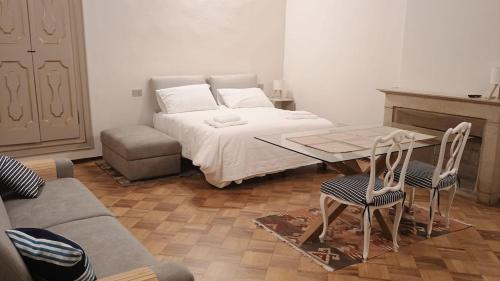 a bedroom with a bed and a table and a couch at FuoriPorta Affitti Brevi - L'Appartamento della Musica in Parma