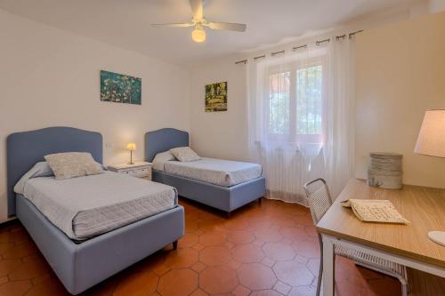 - une chambre avec 2 lits, un bureau et une table dans l'établissement Agriturismo Villa Beatrice, à Mondavio