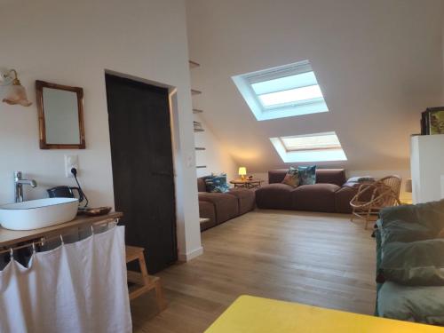 a living room with skylights and a living room with a couch at Le grenier à sel, maison de pécheur pour 6 avec salle TV in Fécamp