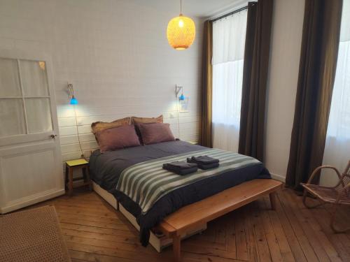 a bedroom with a bed with shoes on it at Le grenier à sel, maison de pécheur pour 6 avec salle TV in Fécamp