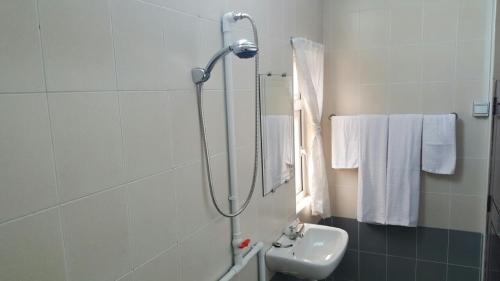 een badkamer met een douche en een wastafel bij Pandora Motel in Yangon