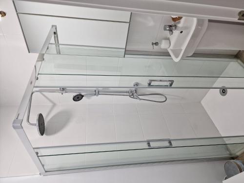 een douche met glazen wanden in een badkamer met een wastafel bij Aurora2 Alcazar - Alojamiento en centro histórico in Úbeda