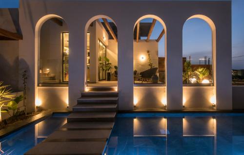 a villa with a swimming pool at night at VAYA Suites by Omilos Hotels in Amoudara Herakliou